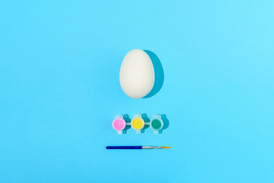 Easter egg painting set. Brush and paint on light blue background