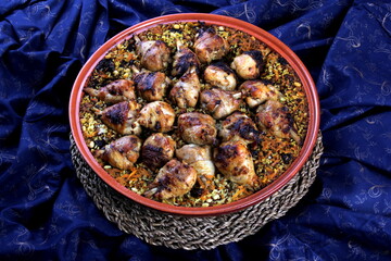 Traditional Tajine Berber Dish Made with Chicken Legs, couscous or rice, blue fabric background