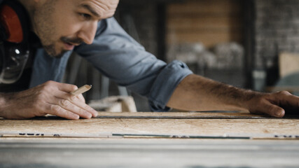 Worker sketching on wood