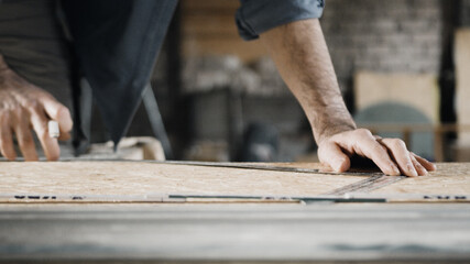 Worker sketching on wood