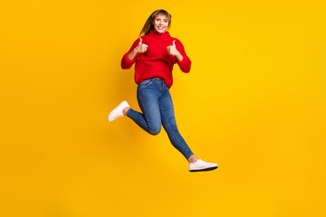 Fototapeta na wymiar Full size profile photo of blond optimistic lady jump thumb up wear red sweater jeans sneakers isolated on bright yellow color background