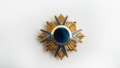 Jewelry on a dark background, yellow metal medal with blue details