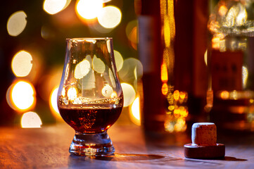 Glasses of scotch whisky served in bar in Edinburgh, Scotland, UK and pasry lights on background