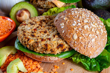 Tasty vegetarian healthy food, homemade burgers made from orange lentils legumes with green lettuce and fresh ripe avocado