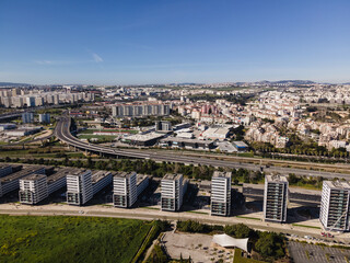 Lisbon, Portugal - 14 February 2021: Aerial view of a modern residential district with a busy highway road crossing Lisbon suburban district, Oriente, Portugal.