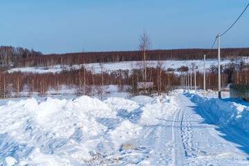 Piles of snow after the work of a tractor to clear rural roads in winter the consequences of heavy snowfall