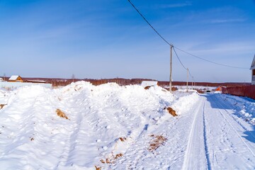 Beautiful calm winter rural landscape with brick house, snow in fields and road
