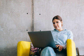 Young woman mobile developer with laptop, writes program code on a computer, programmer work in...