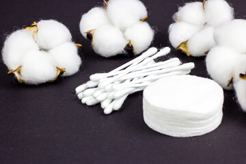 White soft cotton pads and sticks for hygiene and healthcare on black background. © KatMoy