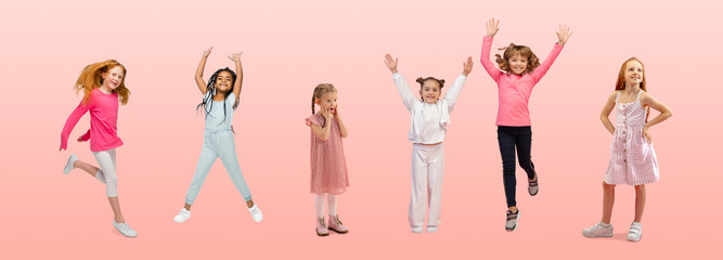 Fototapeta na wymiar Friendship. Group of elementary school kids or pupils jumping in colorful casual clothes on pink studio background. Creative collage. Back to school, education, childhood concept. Cheerful girls.