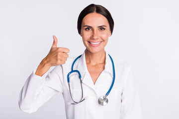 Photo of cute good mood young woman physician wear formal coat showing thumb up smiling isolated white color background