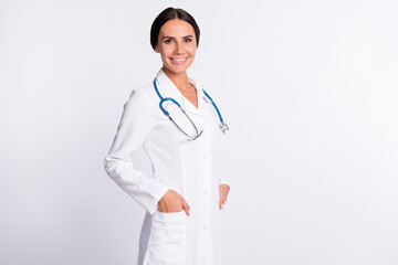 Photo of good mood pretty young lady doctor dressed uniform smiling arms pockets isolated white color background