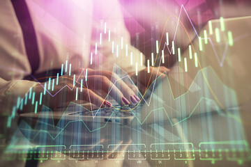 Double exposure of businesswoman hands typing on computer and financial graph hologram drawing. Stock market analysis concept.