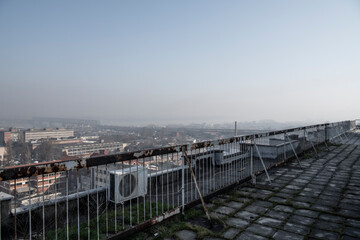 Fototapeta na wymiar Smog lies over the skyline of Historical architecture of Belgrade city. Poor visibility, smog, caused by air pollution. Rooftop view. Emissions of plants and factories. Belgrade, Serbia 25.02.2021