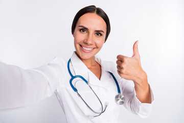 Fototapeta premium Photo of good mood positive young lady medic dressed uniform recording video showing thumb up isolated white color background