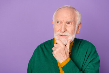 Photo of intelligent man arm on chin look interested empty space thinking isolated on pastel violet color background