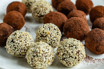 truffles with cocoa, coconut and sesame seeds with chocolate and marshmallows, delicious dessert on a white background