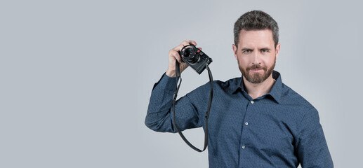 Bearded man in casual shirt hold film camera grey background, analog photography