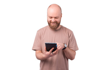 Joyful young bearded man using tablet over white background