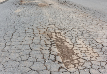 asphalt roads in damaged condition with holes in cracks and bumps are dangerous for road users