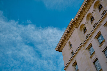 Blue sky and white clouds with corner of the nice architectural building or house in capital of Sofia, Bulgaria