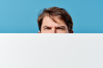 peeping from behind a billboard advertisement copy space isolated background close-up