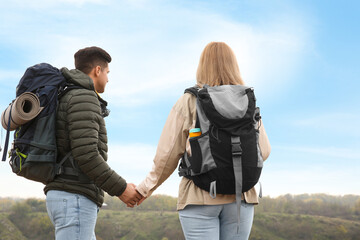 Obraz na płótnie Canvas Couple of hikers with travel backpacks enjoying nature on autumn day, back view