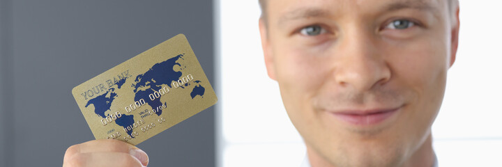 Fototapeta premium Smiling businessman holds plastic bank card in his hand. Development of the banking sector and services to the population concept