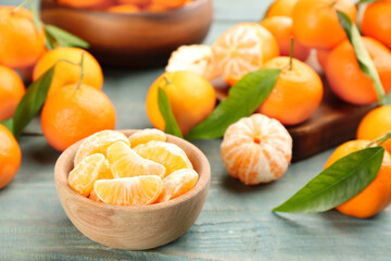 Fototapeta na wymiar Fresh tangerine slices on blue wooden table