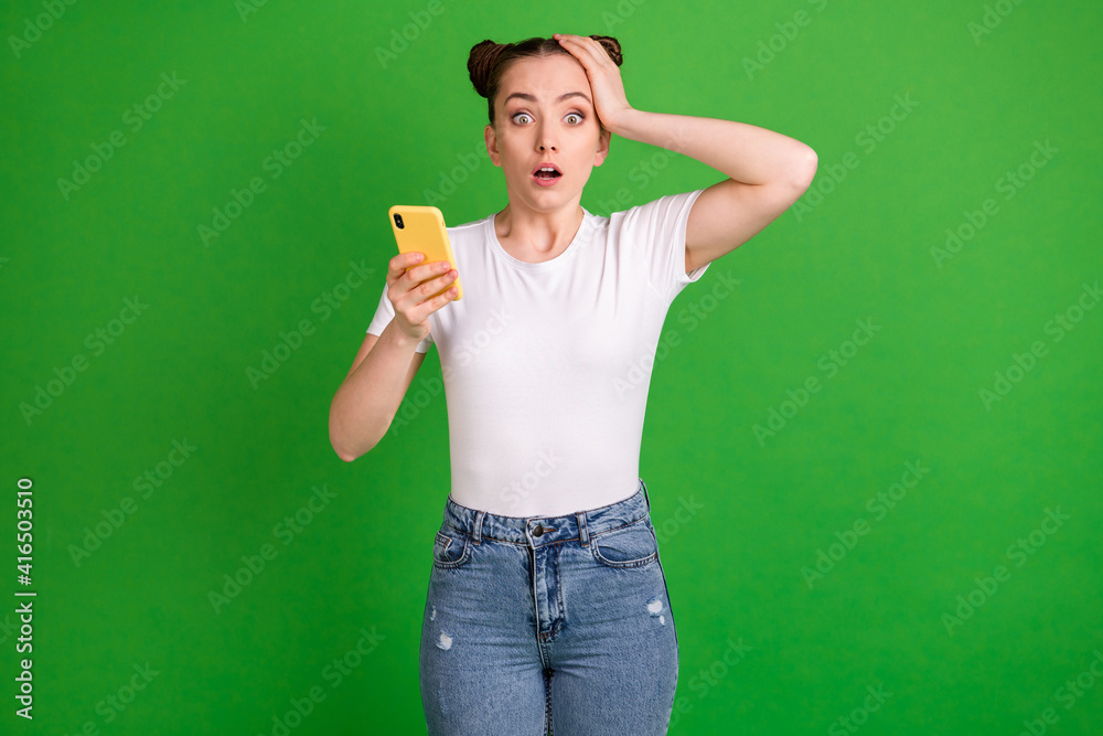 Poster Photo of crazy troubled lady hold cellphone hand head open mouth wear white t-shirt isolated green background