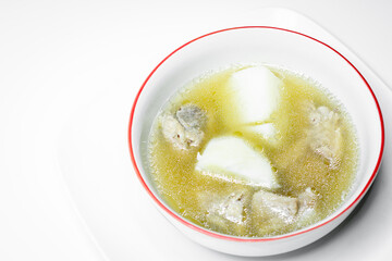 Pork rib soup and potato in white bowl on white background.