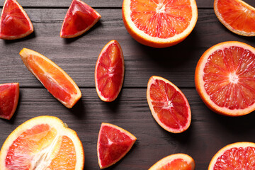 Cut fresh ripe red oranges on wooden table, flat lay