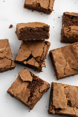 Pieces of freshly baked brownies in a square form. Flat lay composition with tasty, sweet brownies isolated on white background. Delicious chocolate pie. Dessert menu concept.