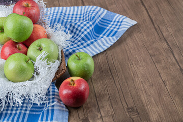 Apples in a wooden basket on a white burlap