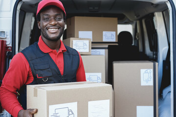 Black courier man delivering package in front of cargo truck - Shipping concept - Focus on face