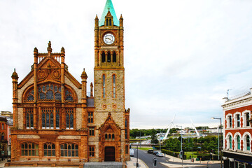 Fototapeta premium Derry, North Ireland. Aerial view of Derry Londonderry city center in Northern Ireland, UK. Sunny day with cloudy sky, city walls and historical buildings