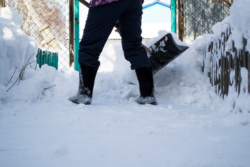 A man that is standing in the snow.The girl cleans the snow with a paw.