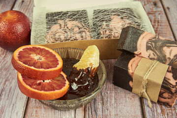Natural handmade soap with chocolate and orange on a wooden countertop.
