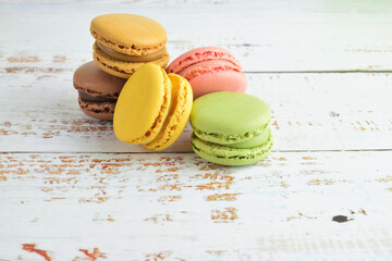 Macarons, typical french sweet. White rustic table background. Copy space.