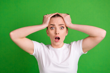 Photo portrait of amazed girl staring opened mouth with top knots isolated on bright green color background