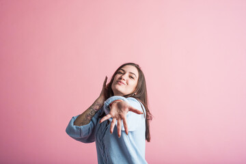 Smiling, happy and winning brunette girl in studio on pink background