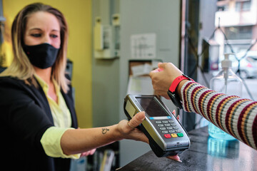 a woman pay using smartwatch using contactless technology - new normal