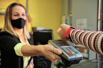 a woman pay using smartwatch using contactless technology