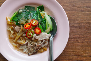 Fried Wide Rice Noodles with Pig in Gravy Sauce on the Wood Table.