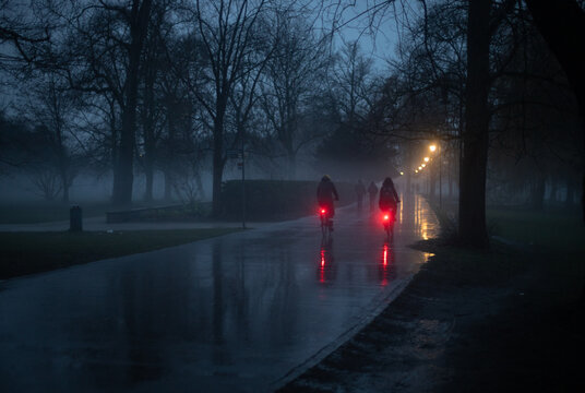 Fototapeta Evening view of the people riding at the bicycles at the winter park