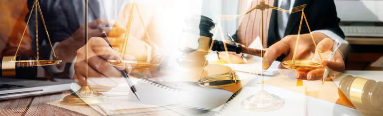 Justice and law concept.Male judge in a courtroom with the gavel, working with, computer and docking keyboard, eyeglasses, on table in morning light