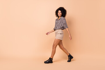 Full length body size side profile photo of going forward curly girl wearing casual outfit isolated on pastel beige color background