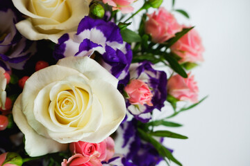 Background. Bouquet of flowers close-up on a white background. White and pink roses, blue-white eustoma. Place for text.
