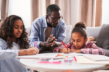Girls drawing pictures and showing it to their father - obrazy, fototapety, plakaty