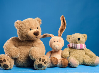 brown teddy bear and cute rabbit sit on a blue background